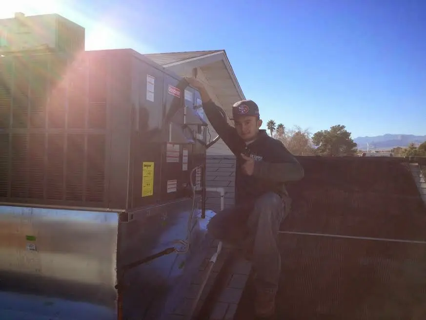 HVAC technician performing AC Tune-Up on a rooftop unit in Mamaroneck